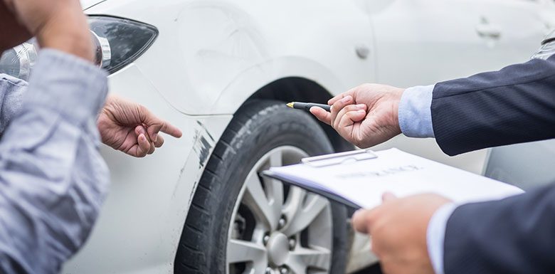 insurance adjuster inspecting car damage
