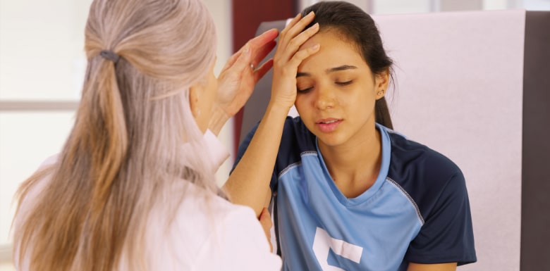 Woman examining injured child athlete