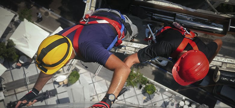 Construction workers on the side of a tall building