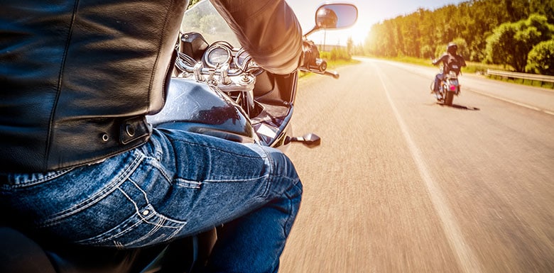 Two motorcyclists driving on road