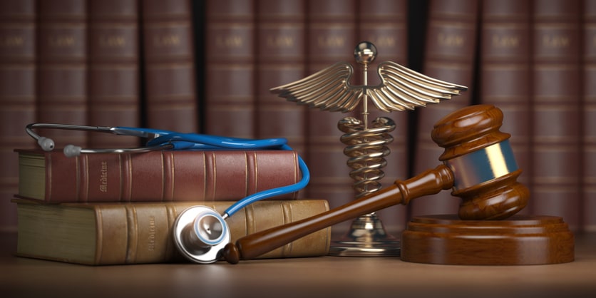 Gavel, stethoscope and caduceus sign on books