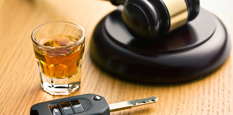 shot of liquor and car keys with gavel