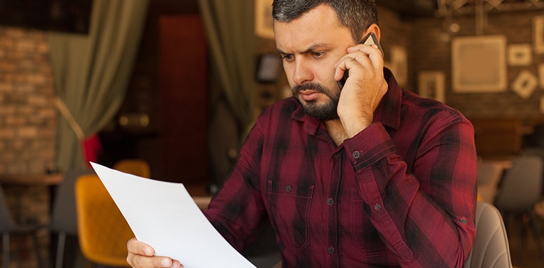 man on phone reading mail