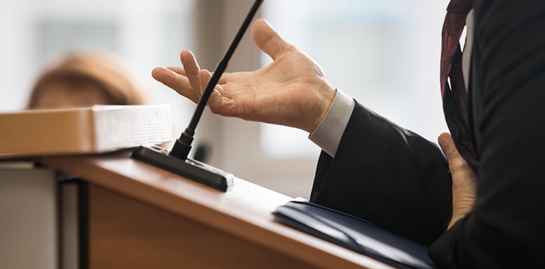 man speaking in microphone at court