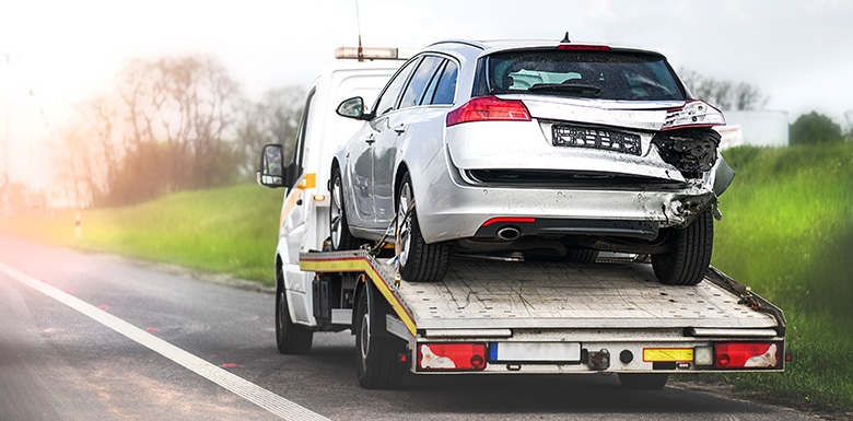 damaged car on tow truck