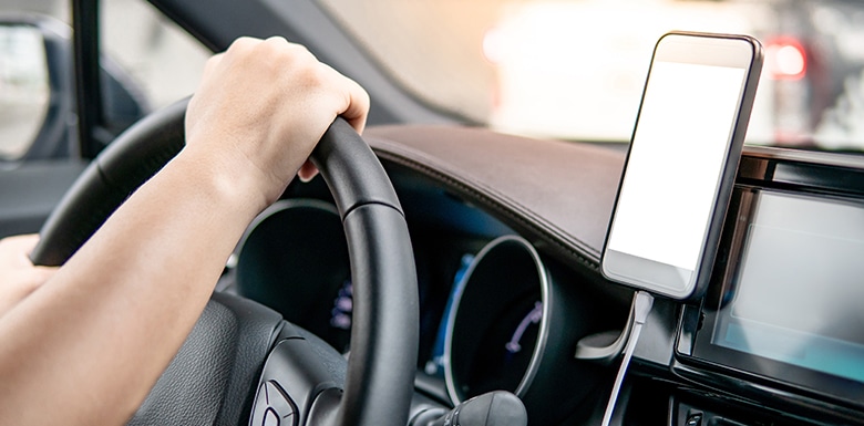 Phone plugged in on dashboard of car