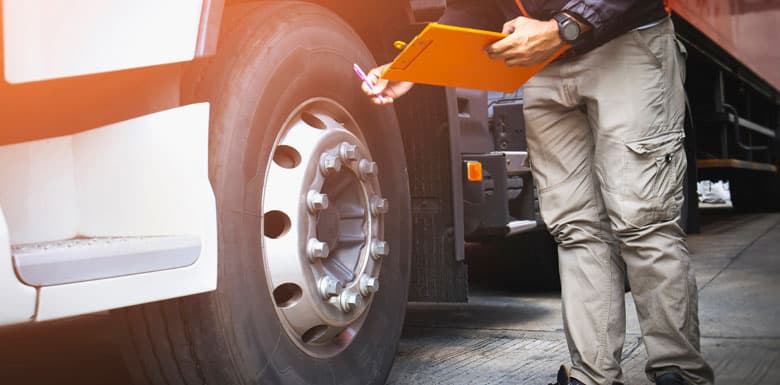 Mechanic doing a safety inspection on a semi truck